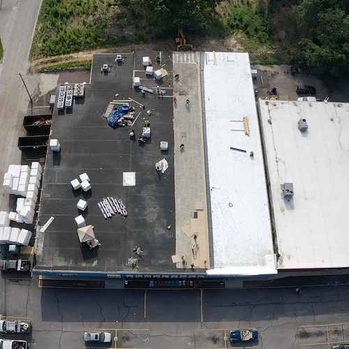 Roofers install commercial roof.