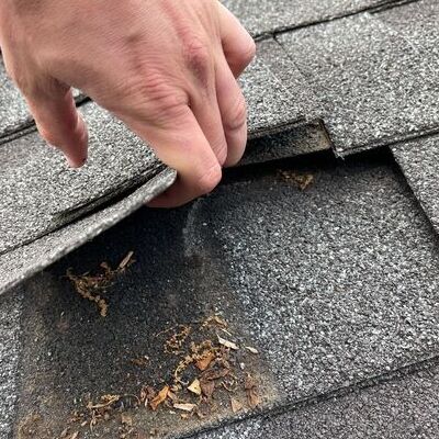 Roofer examines damage.